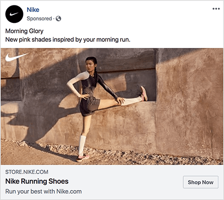 Detta är en Facebook-annons för Nike-löparskor. Annonstexten säger "Morning Glory" och på nästa rad "Nya rosa nyanser inspirerade av din morgonlöpning." På annonsfotot, en asiatisk kvinna sträcker sig med ett ben sträckt rakt ut och hennes fot på en avsats och hennes andra fot på jord. Hennes övre halva vrids åt sidan. Hon har rosa Nike-löparskor, vita knestrumpor och mörkgrå löparbyxa och en linne. Hennes hår dras upp. Hon är på en grusväg framför en byggnad med stuck eller jord. Talia Wolf säger att Nike är ett bra exempel på ett varumärke som använder känslor i reklam.