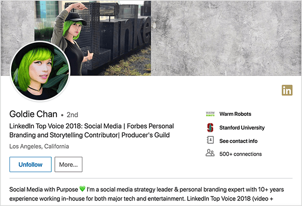 Detta är en skärmdump av Goldie Chans LinkedIn-profil. Hon är en asiatisk kvinna med grönt hår. På hennes profilfoto har hon smink, ett svart chokerhalsband och en svart skjorta. Hennes tagline säger ”LinkedIn Top Voice 2018: Sociala medier | Forbes Personal Branding and Storytelling Contributor | Producer's Guild ”