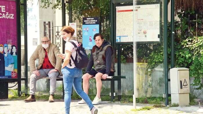 Kaya Çilingiroğlu visas utan en mask vid busshållplatsen.