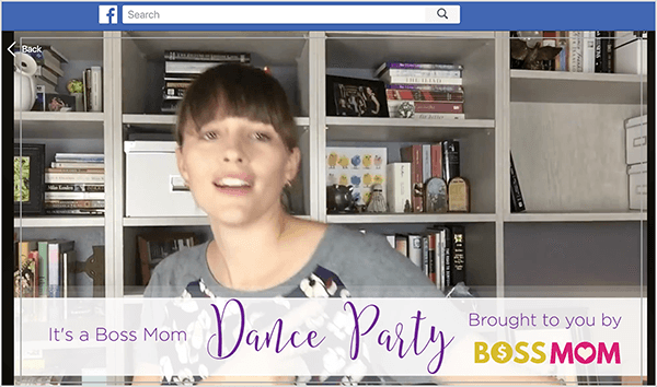 Detta är en skärmdump av Dana Malstaff som dansar i en Facebook-video som hon skapade för att fira en milstolpe i sin Facebook-grupp. Dana är en vit kvinna avbildad från bröstet framför en vit bokhylla med böcker och vita arkivlådor. Hennes hår är mörkbrunt med lugg och resten dras tillbaka i en hästsvans. En banderoll längst ner i videon säger "Det är ett Boss Mom Dance Party som du får av Boss Mom."