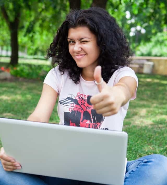 Flicka på bärbar dator i park