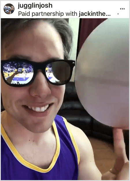 Josh Horton publicerar ett foto för en kampanj med Jack in the Box och LA Lakers. Josh bär speglade solglasögon och en Lakers-tröja och ler mot kameran medan han snurrar en boll.